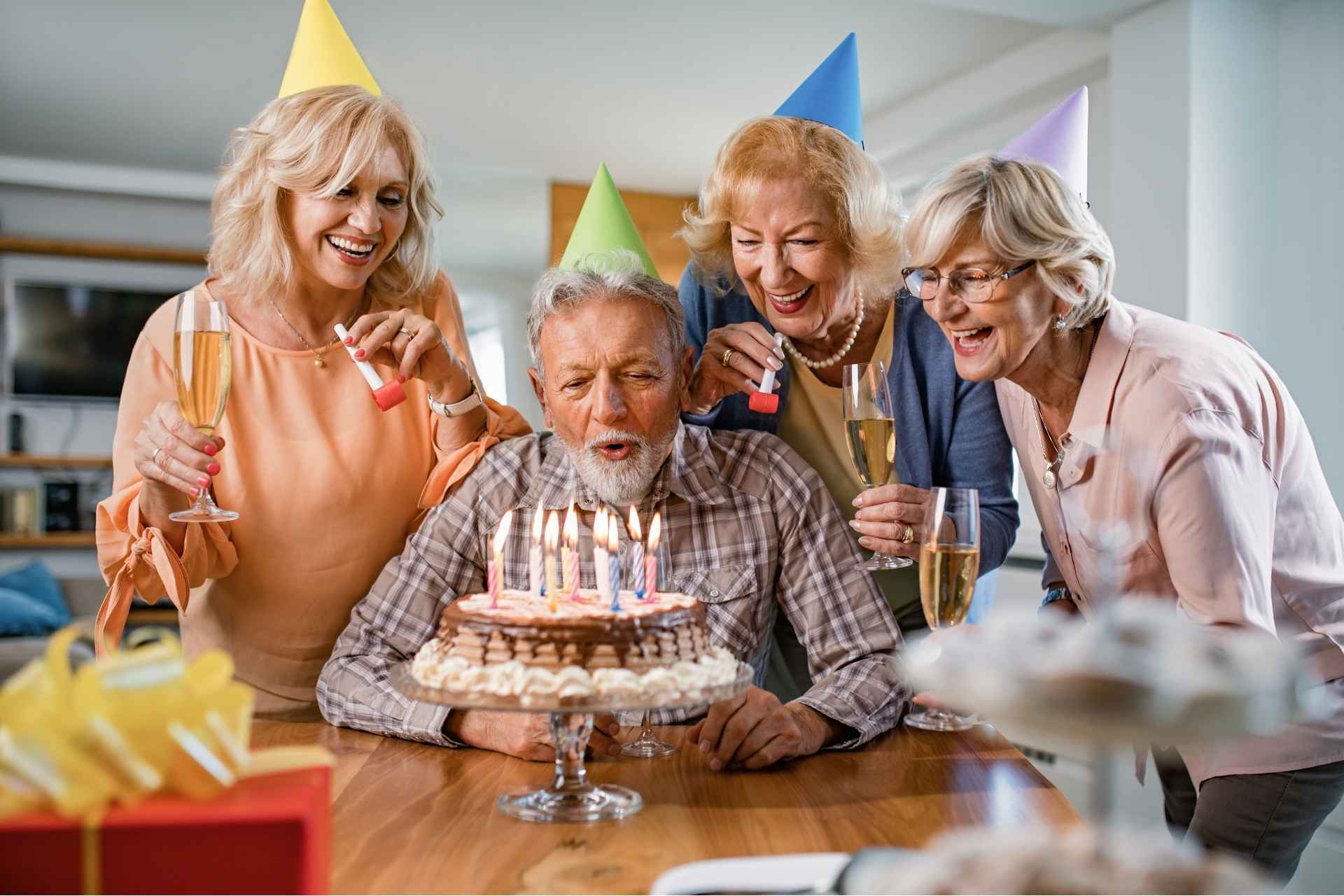 senior blows out candles on birthday cake